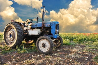 old blue tractor on edge of farm where new digital transformation strategies are being considered